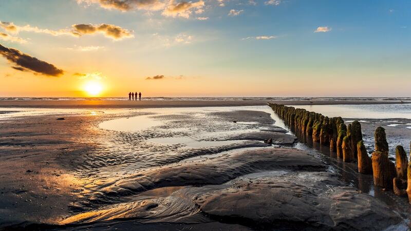 Sunset over mudflat with hiking group on the horizon. © Janis Meyer/Waddenagenda. Sunset over mudflat with hiking group on the horizon. © Janis Meyer/Waddenagenda.